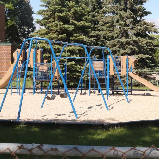 Swings and a play structure at Murray Sinclair Park