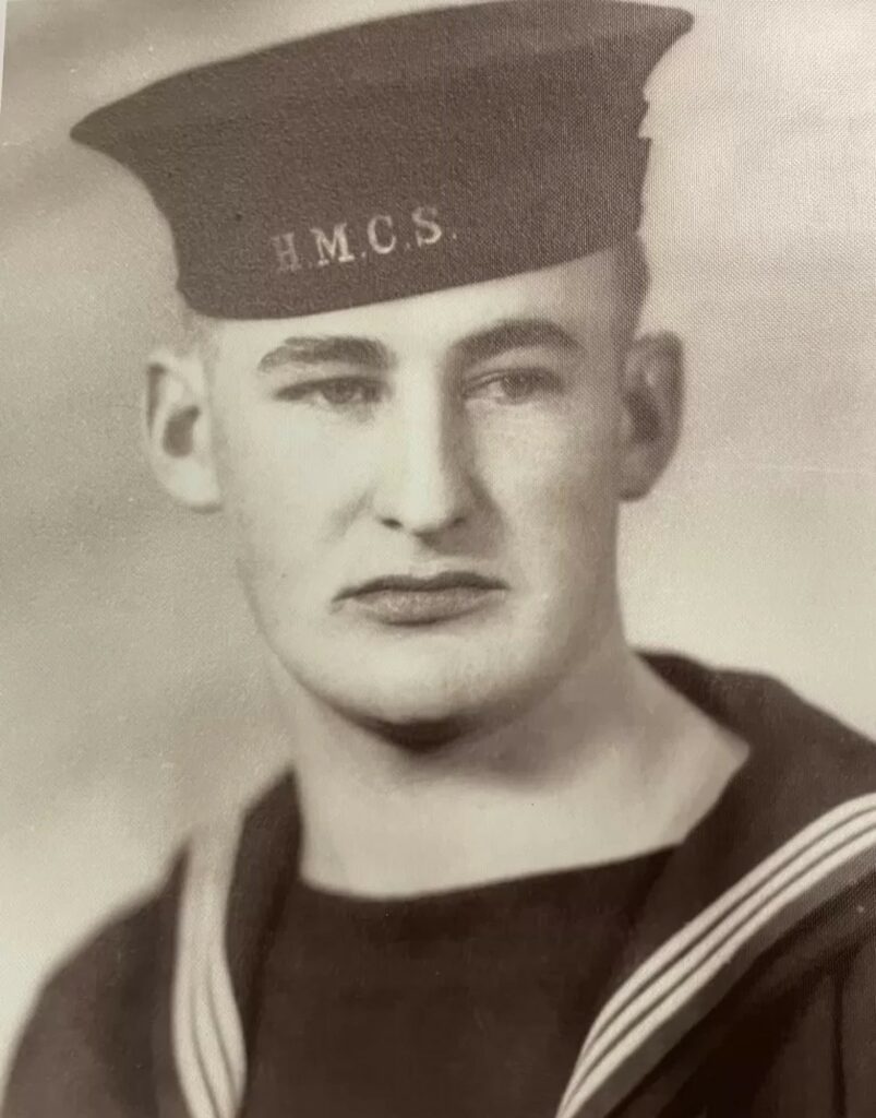 A blakc and white image of a young man in navy uniform. He looks to the right of the camera