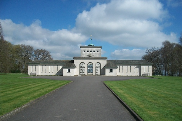 Colour photo of a large rectangular building with a long concrete walking path leading up to it