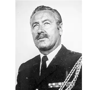 A black and white image of a man in military uniform. He has a moustache and is wearing a white shirt with a tie. He looks off to the left side of the camera