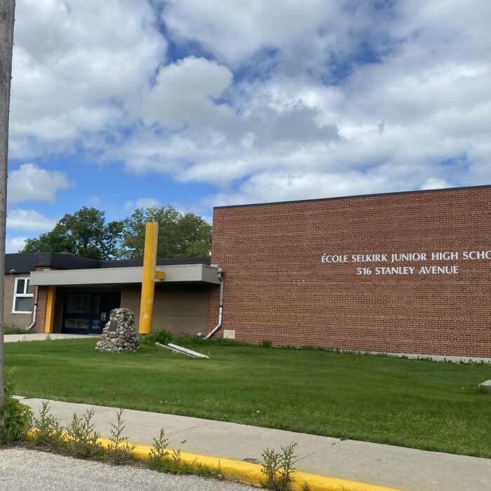 École Selkirk Junior High, 2024, Selkirk Museum Collection Colour image of a school. On the right side of the image is a large brick gymnasium. On the left is the school's entrance