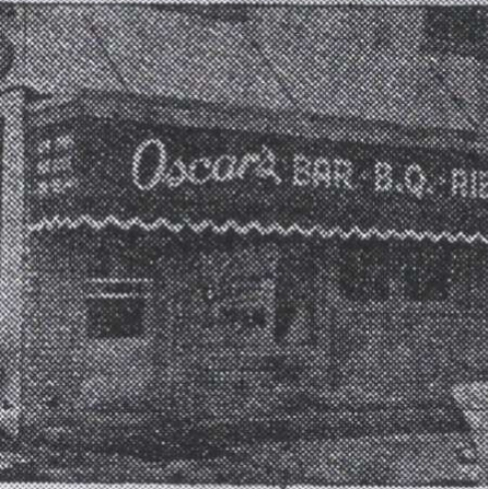 Black and white photo of Oscar's Restaurant. The building has an awning with the words 'Oscar's Bar B. Q. Ribs'