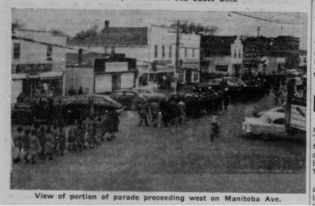 Photo from the Coronation Parade on Manitoba Avenue. The photo is grainy, black and white, and shows a parade procession coming down Manitoba Ave