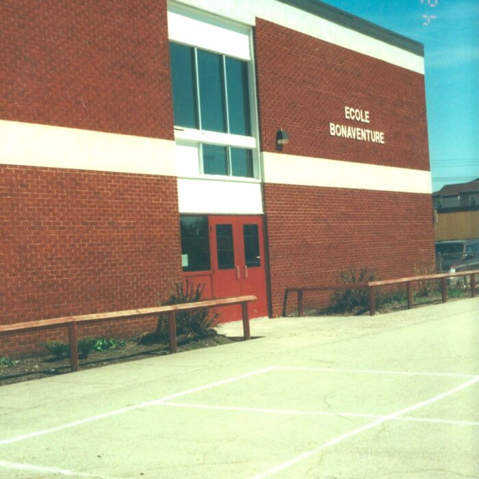 École Bonaventure part of Selkirk Junior High, 1998, Cecile Barrett Colour photo of a brick building with white trim and red doors