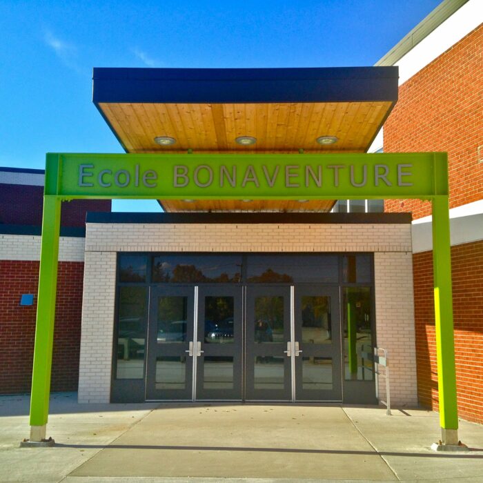 New Entrance of Ecole Bonaventure, 2015, Cecile Barrett Colour photo of the entrance to a school. There is a vibrant green sign and a wood cover over the entrance