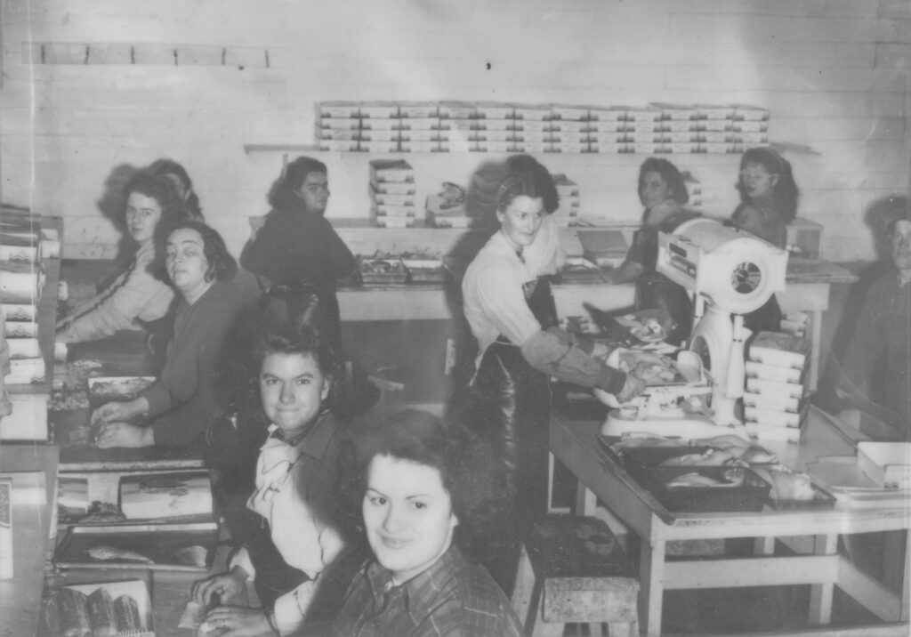 Black and white photo of a group of women working at booth fisheries