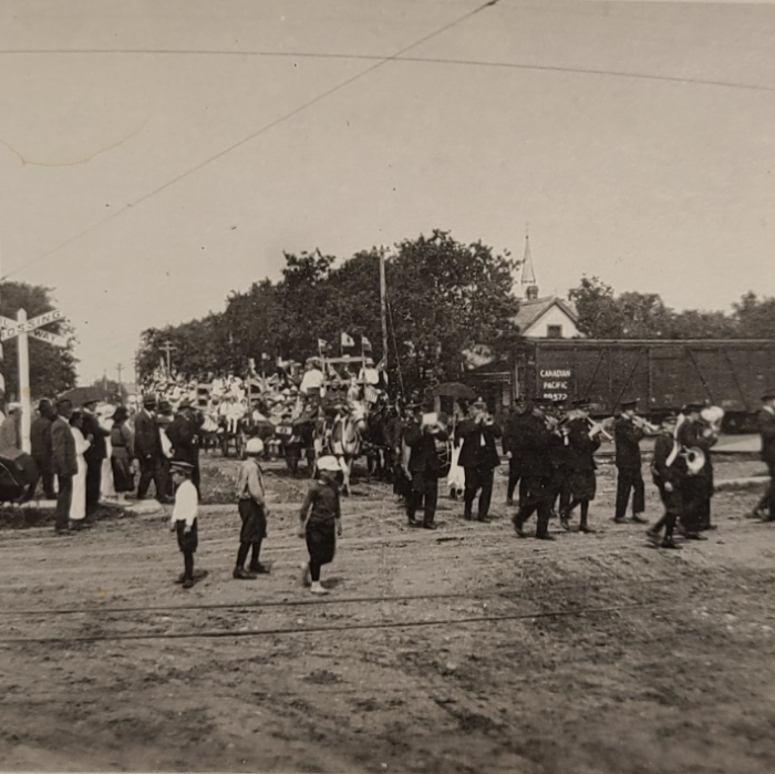 Marching Band Turning Onto Sophia, 1919, Selkirk Museum Collection Black and white photo of a marching band making its way down the street