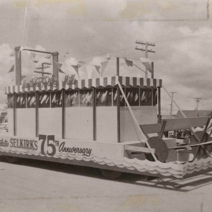 Selkirks 75th Parade Manitoba Rolling Mills, 1957, Selkirk Museum Collection Black and white photo of the Manitoba Rolling Mills parade float which is decorated with pennants and striped trim along the top of the float