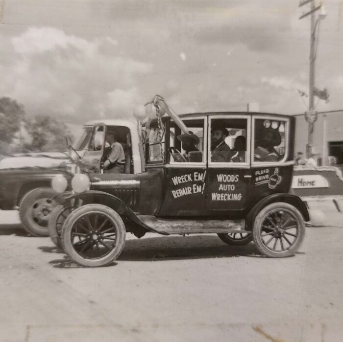 Selkirks 75th Parade Woods Auto Wrecking, 1957, Selkirk Museum Collection Black and white photo of an old car driving in a parade