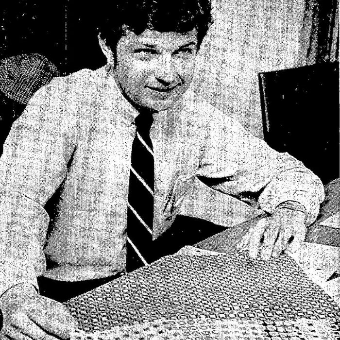 Sebastian Lupu, General Manager of Selkirk’s Electro-Knit Plant, 1969, Winnipeg Free Press Black and white photo of a man seated at a desk . He is wearing a white shirt with a striped tie. He looks to the right and smiles